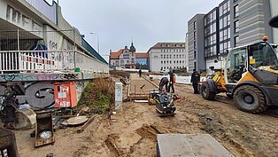 Blick auf die Baustelle mit Baumaschinen und Bagger.
