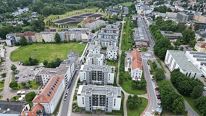 Luftaufnahme mit Wohngebäuden, Straßen und Grünflächen