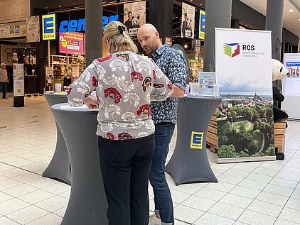 Dame füllt Fragebogen am RGS-Stand aus.